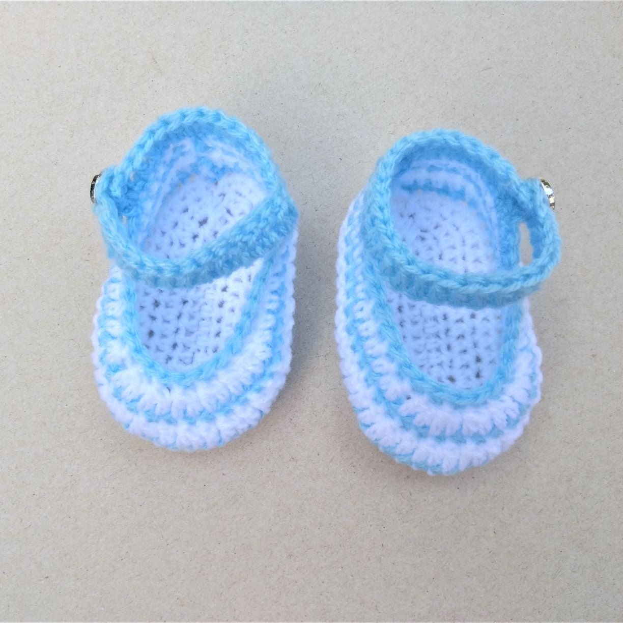 white and blue crochet baby shoes