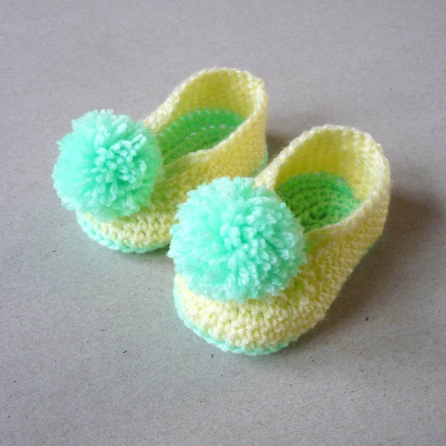 crochet baby shoes with pompoms, yellow and green