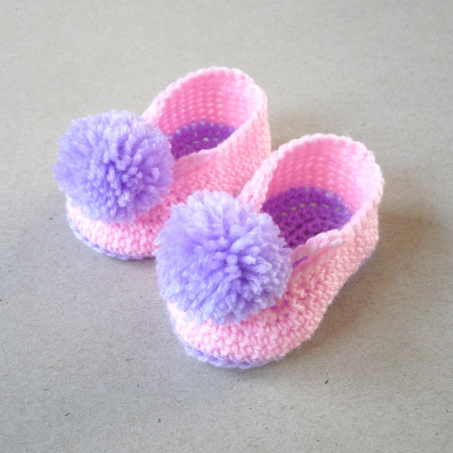 pink and purple crochet baby shoes with pompoms for girls