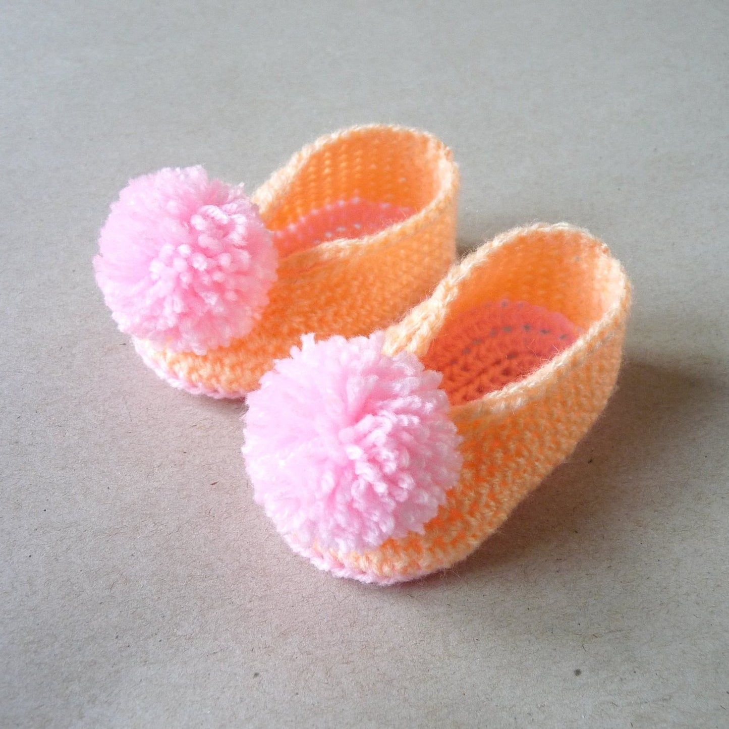 orange and pink crochet baby shoes for girls with pompoms