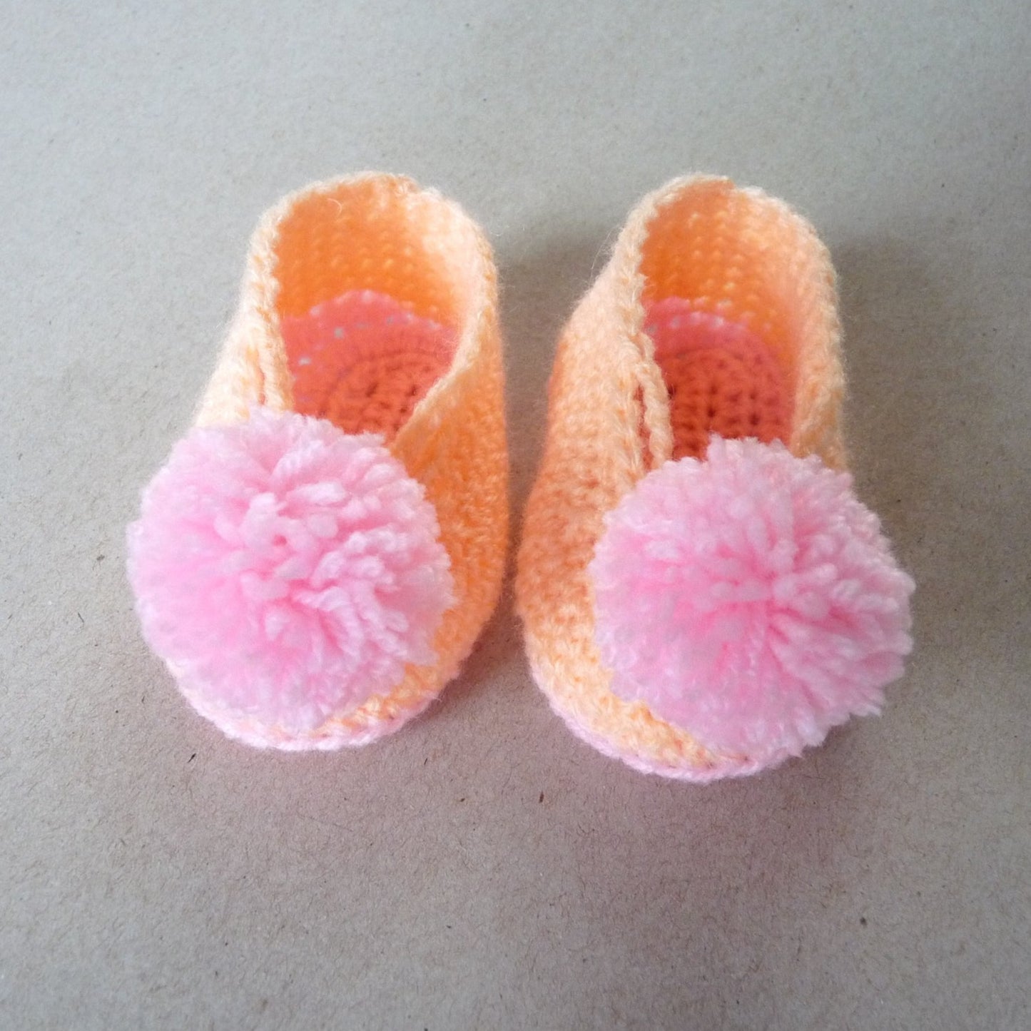 orange and pink crochet baby shoes for girls with pompoms