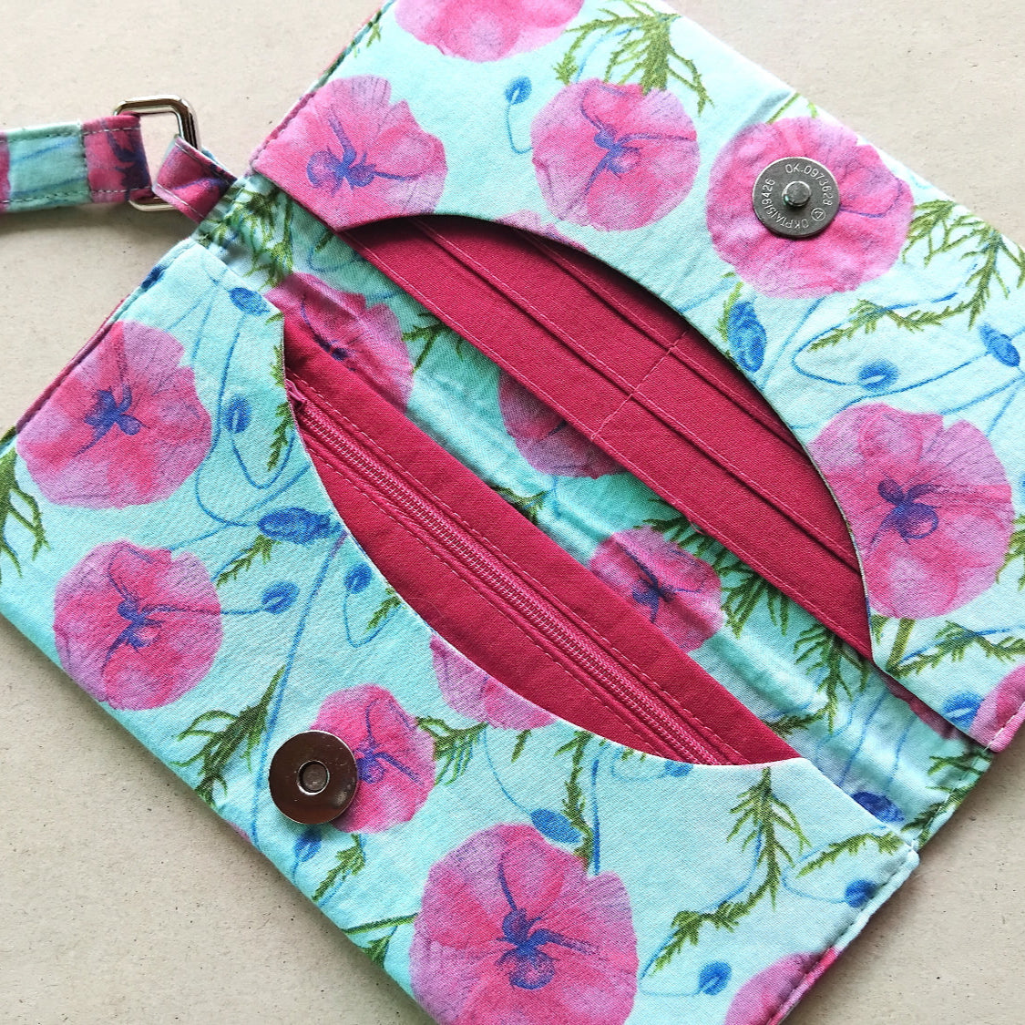 pink and light blue ladies wallet with floral design and wrist strap