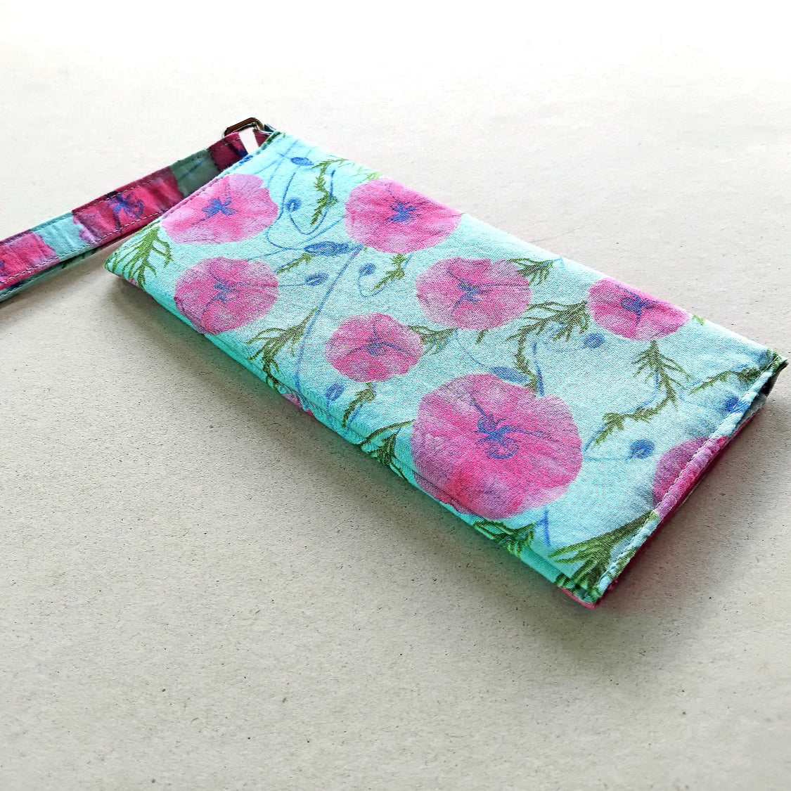 women's wallet made with cotton fabric, it has a pink floral design on a mint blue background