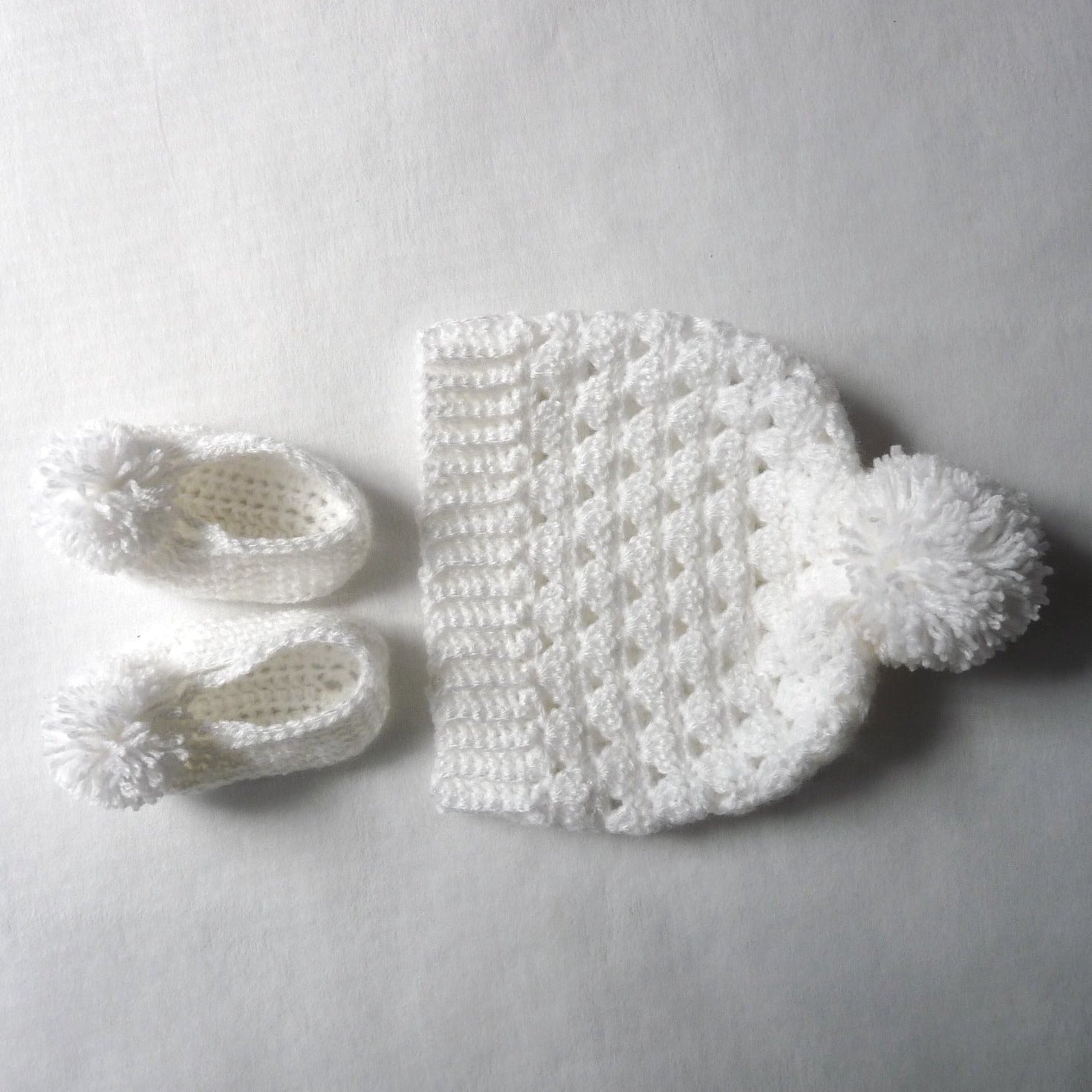 white crochet hat and booties set for babies who are up to 6 months old