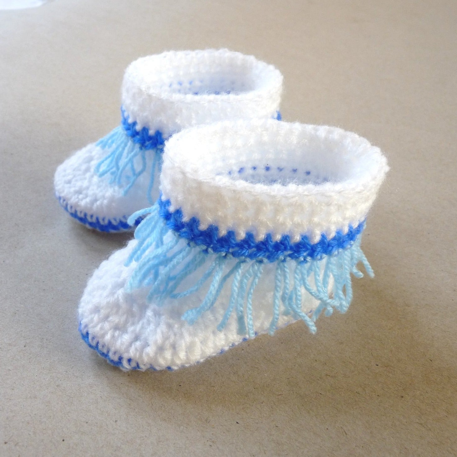 white and blue crochet baby shoes with fringe