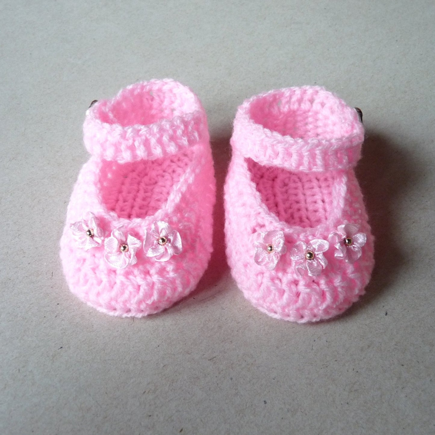 light pink handmade crochet baby shoes with satin ribbon flowers for baby girls